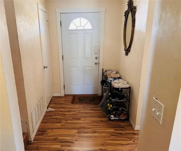 a view of a hallway with wooden floor and stairs