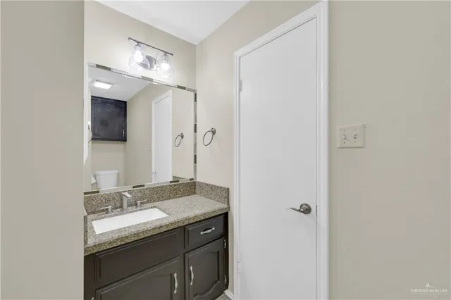 a bathroom with a granite countertop sink and a mirror
