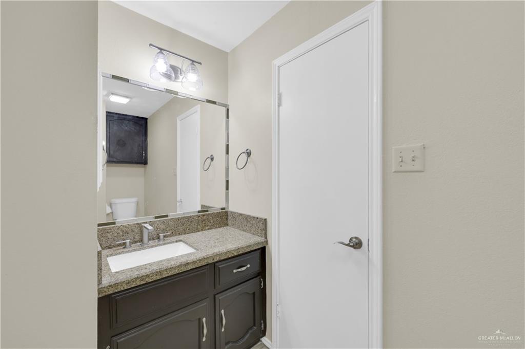 2401 South Jackson Road, Unit 9 Pharr, TX 78577 - Photo 12 of 17 a bathroom with a granite countertop sink and a mirror