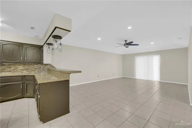 a view of a kitchen with a sink and dishwasher a stove top oven with wooden floor