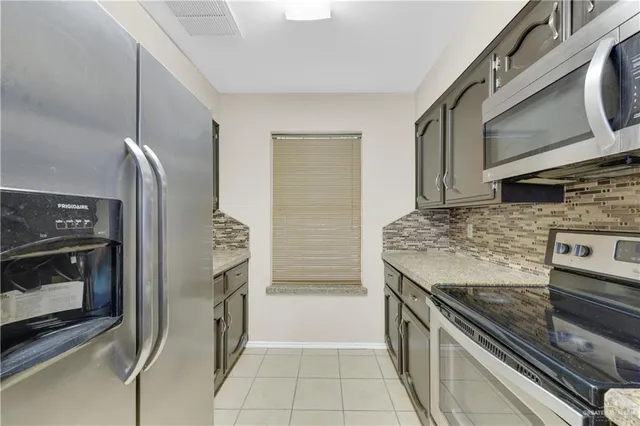 a kitchen with stainless steel appliances granite countertop a stove and a microwave