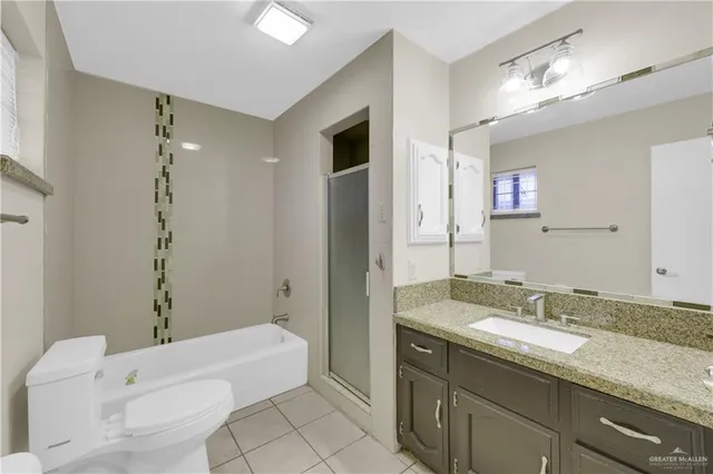 a bathroom with a granite countertop sink a toilet and bathtub