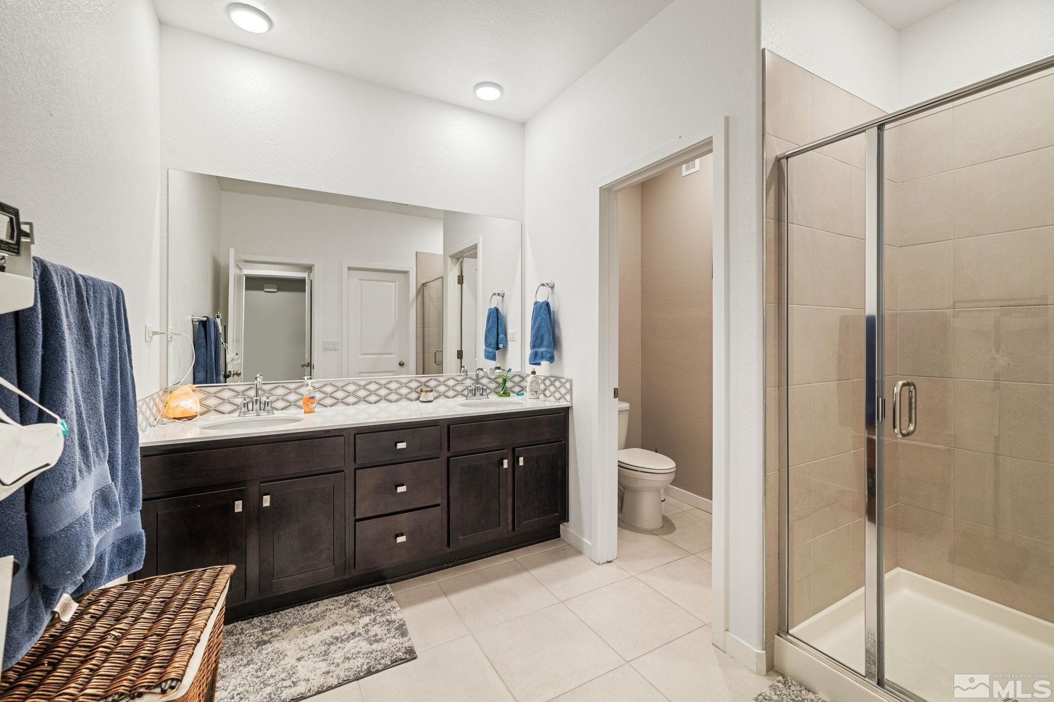 7217 Mustengo Drive Reno, NV 89506 - Photo 21 of 36 a bathroom with a granite countertop sink a toilet and shower
