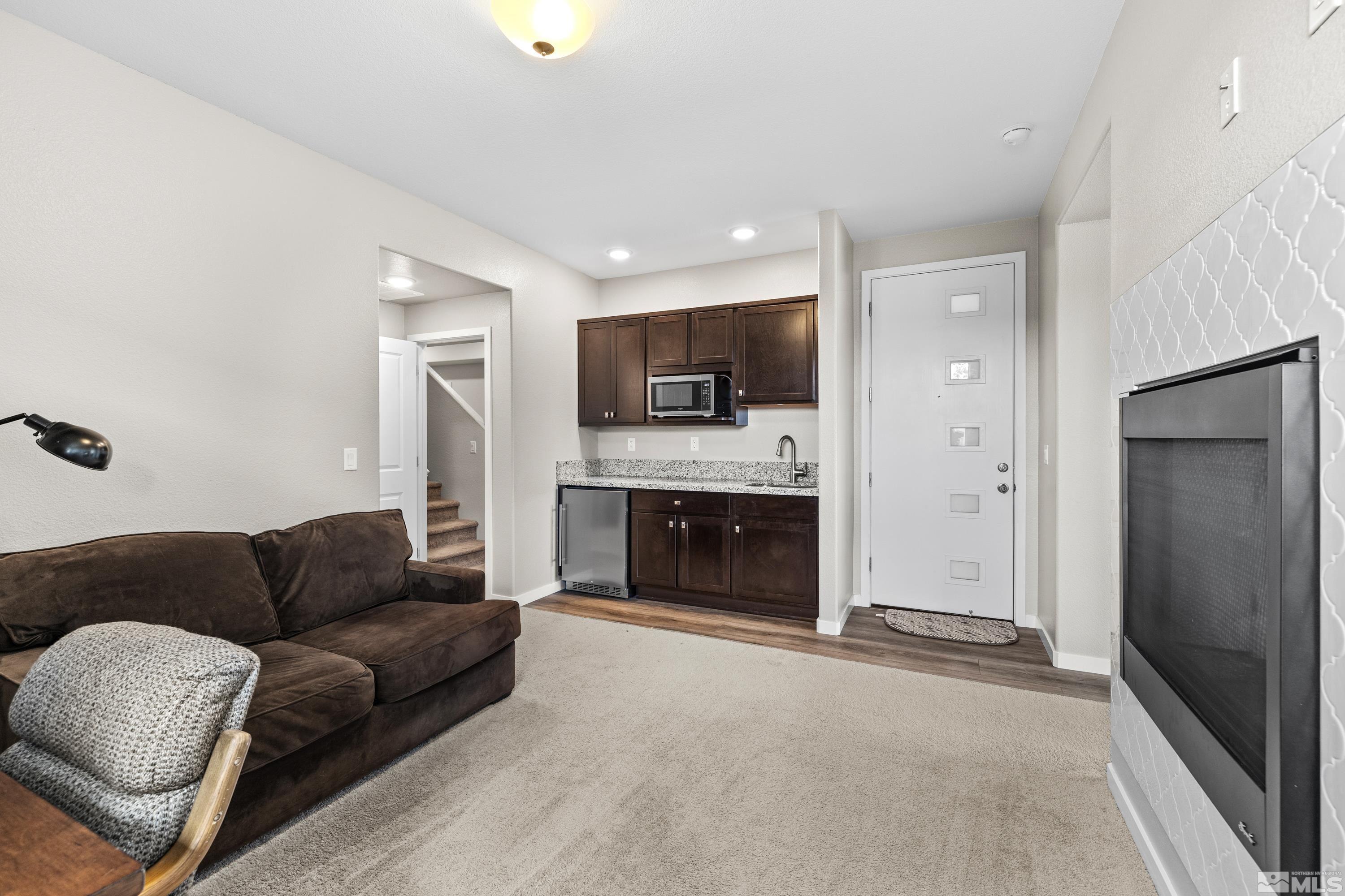 7217 Mustengo Drive Reno, NV 89506 - Photo 23 of 36 a living room with furniture a fireplace and a television