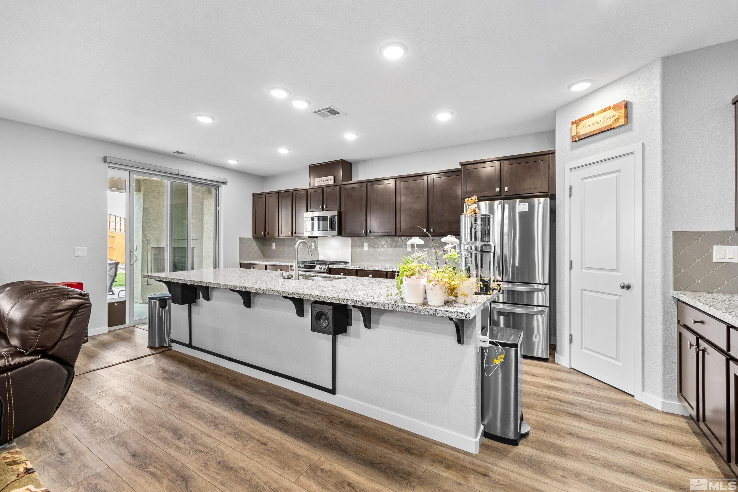 7217 Mustengo Drive Reno, NV 89506 - Photo 33 of 36 a kitchen with stainless steel appliances granite countertop a refrigerator and a stove top oven