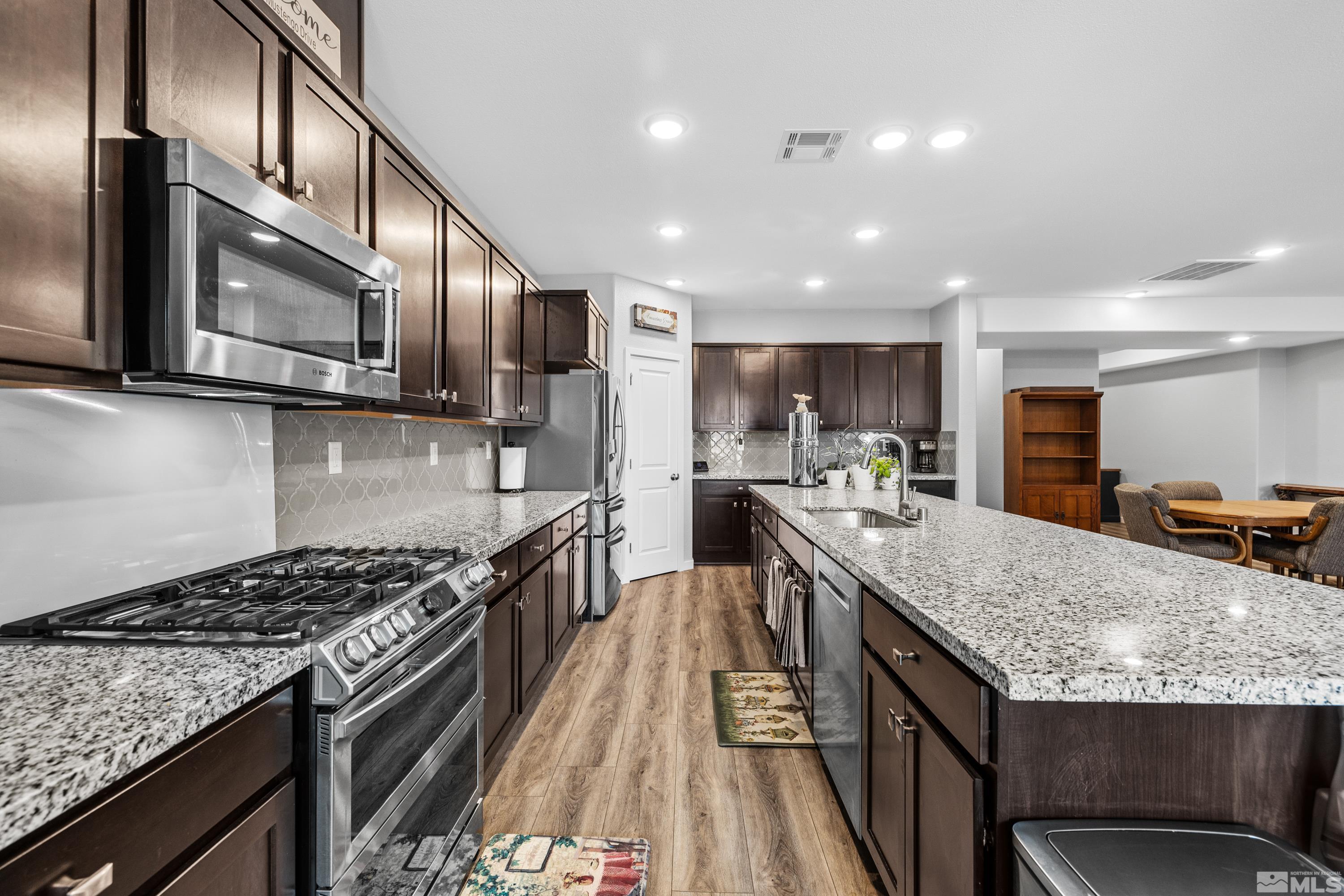 7217 Mustengo Drive Reno, NV 89506 - Photo 35 of 36 a kitchen with stainless steel appliances granite countertop a stove and a sink