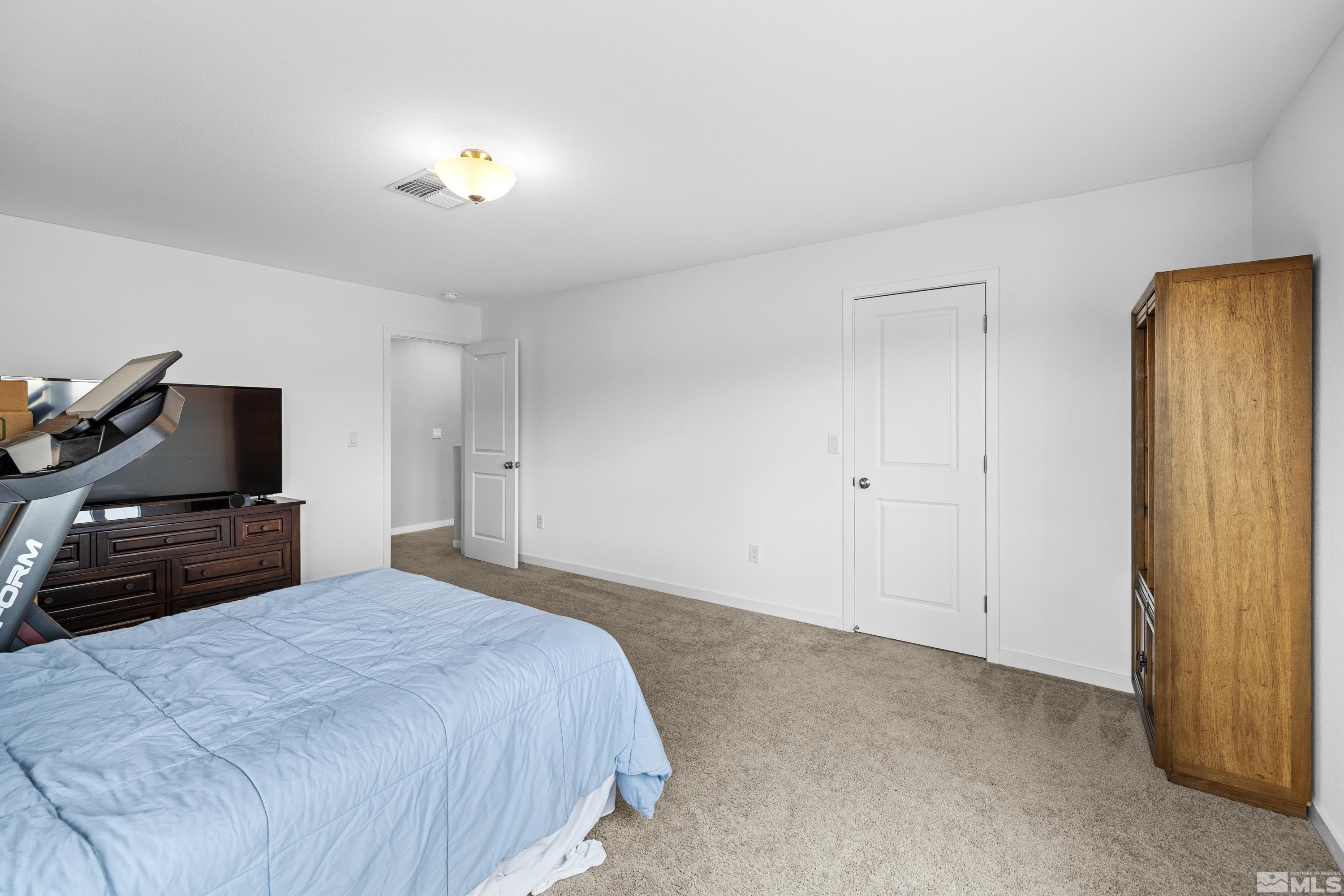 7217 Mustengo Drive Reno, NV 89506 - Photo 10 of 36 a bedroom with a bed and a chandelier