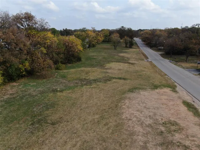 a view of a field with trees in the background
