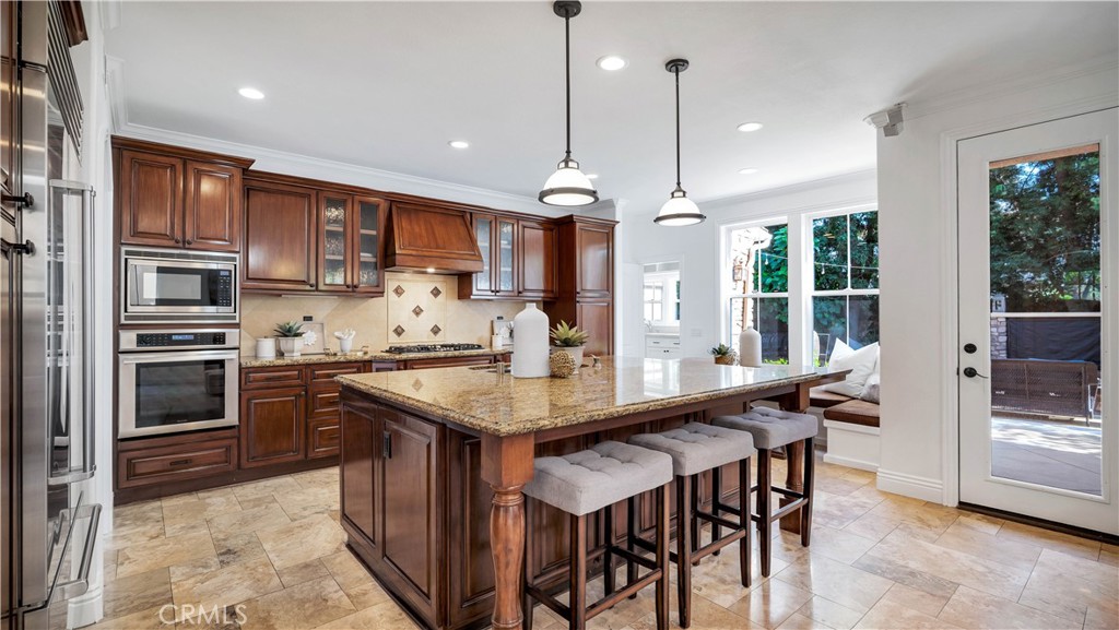 16 Bayleaf Lane Irvine, CA 92620 - Photo 23 of 66 a kitchen with stainless steel appliances granite countertop a stove a refrigerator a sink a dining table and chairs