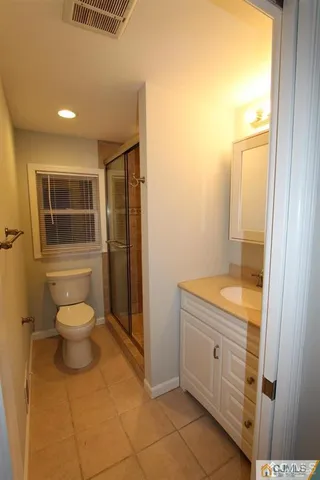 a bathroom with a granite countertop toilet a sink and a mirror