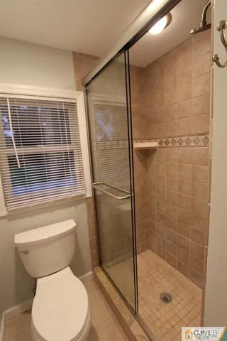 a bathroom with a toilet and a shower