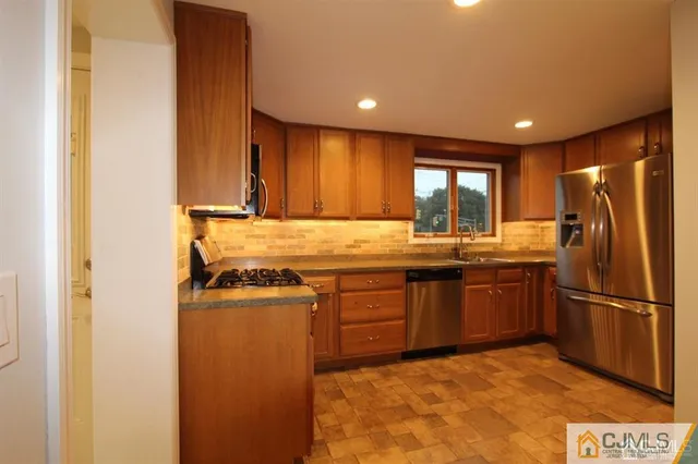 a kitchen with a refrigerator sink and wooden cabinets