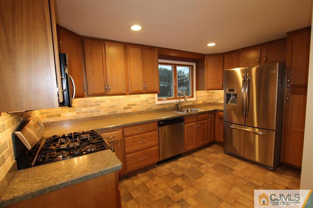 104 Grovers Mill Road Plainsboro, NJ 08536 - Photo 5 of 21 a kitchen with a stove a refrigerator and a sink