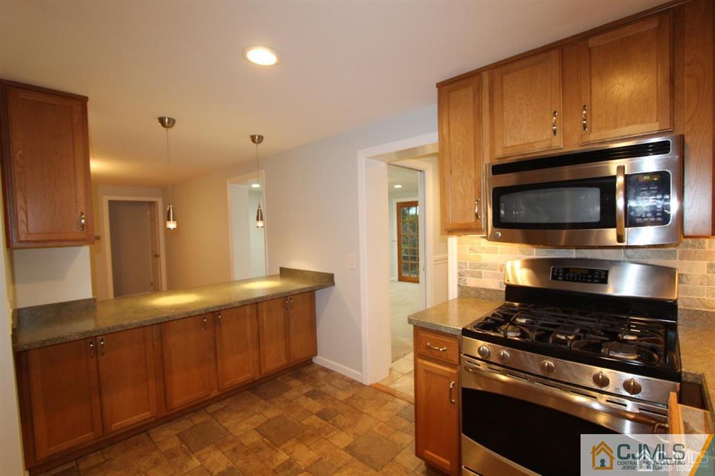 104 Grovers Mill Road Plainsboro, NJ 08536 - Photo 6 of 21 a kitchen with stainless steel appliances granite countertop a stove a microwave and a sink