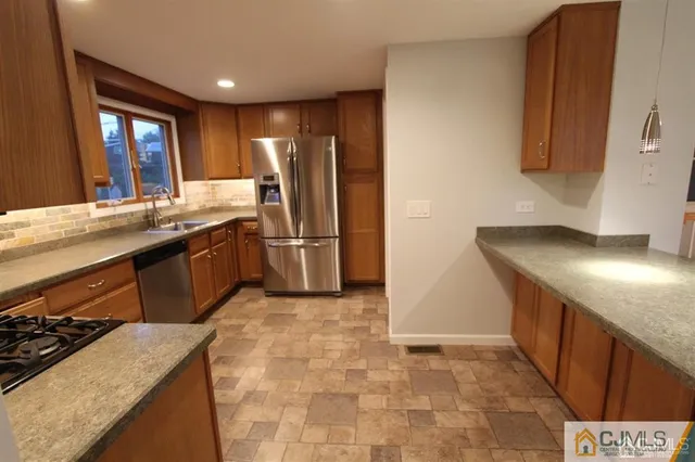 a kitchen with stainless steel appliances granite countertop a sink stove and refrigerator