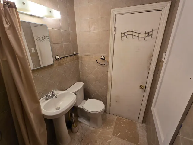 a bathroom with a sink a toilet a mirror and shower