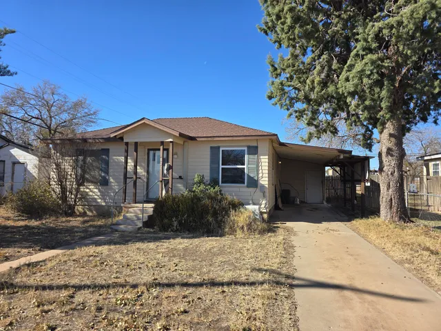 a front view of a house with a yard and tree