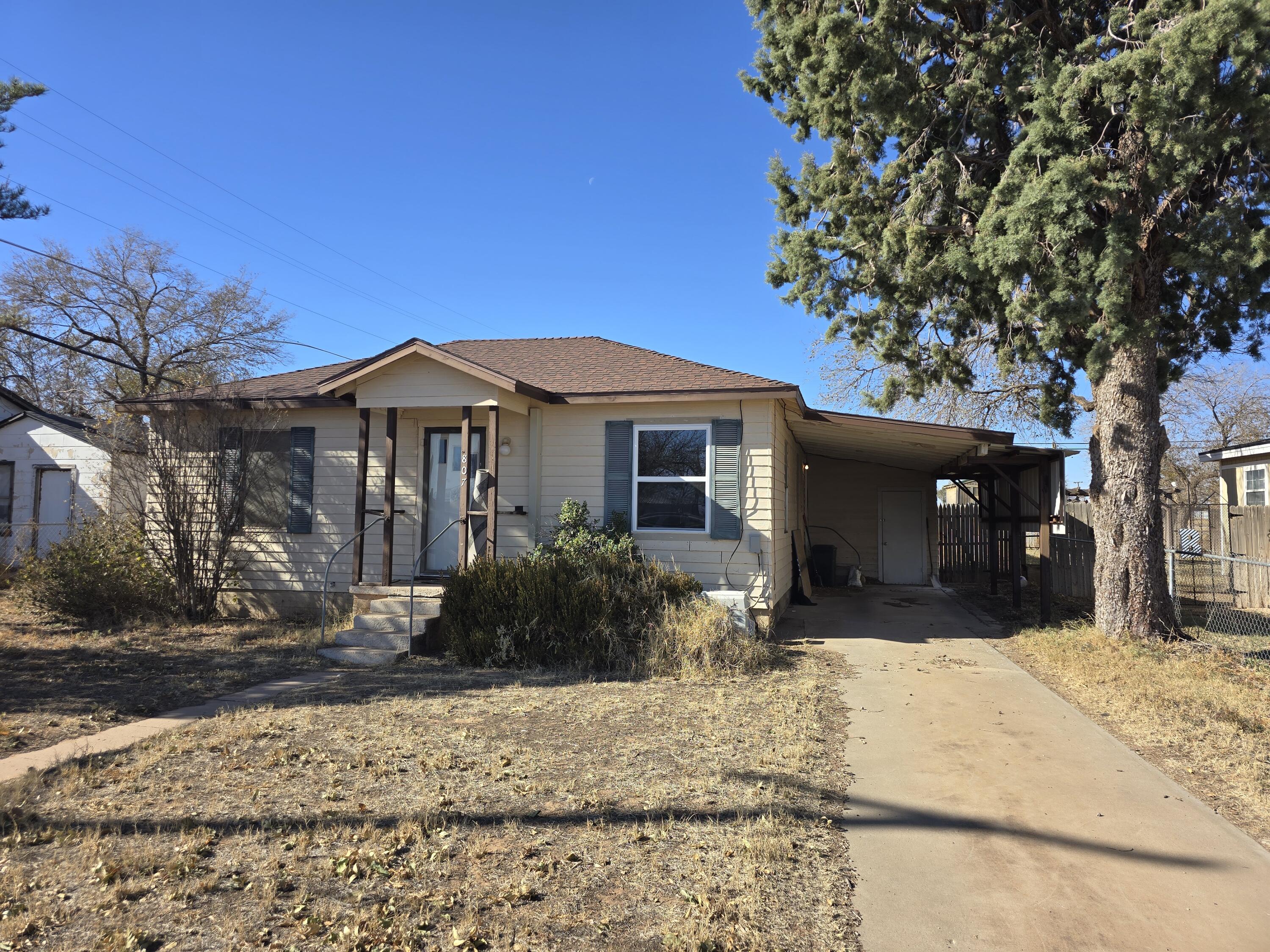 807 Northwest 8th Street Seminole, TX 79360 - Photo 2 of 15 a front view of a house with a yard and tree