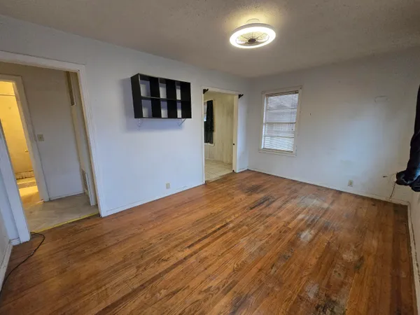 a view of a room with wooden floor and a window
