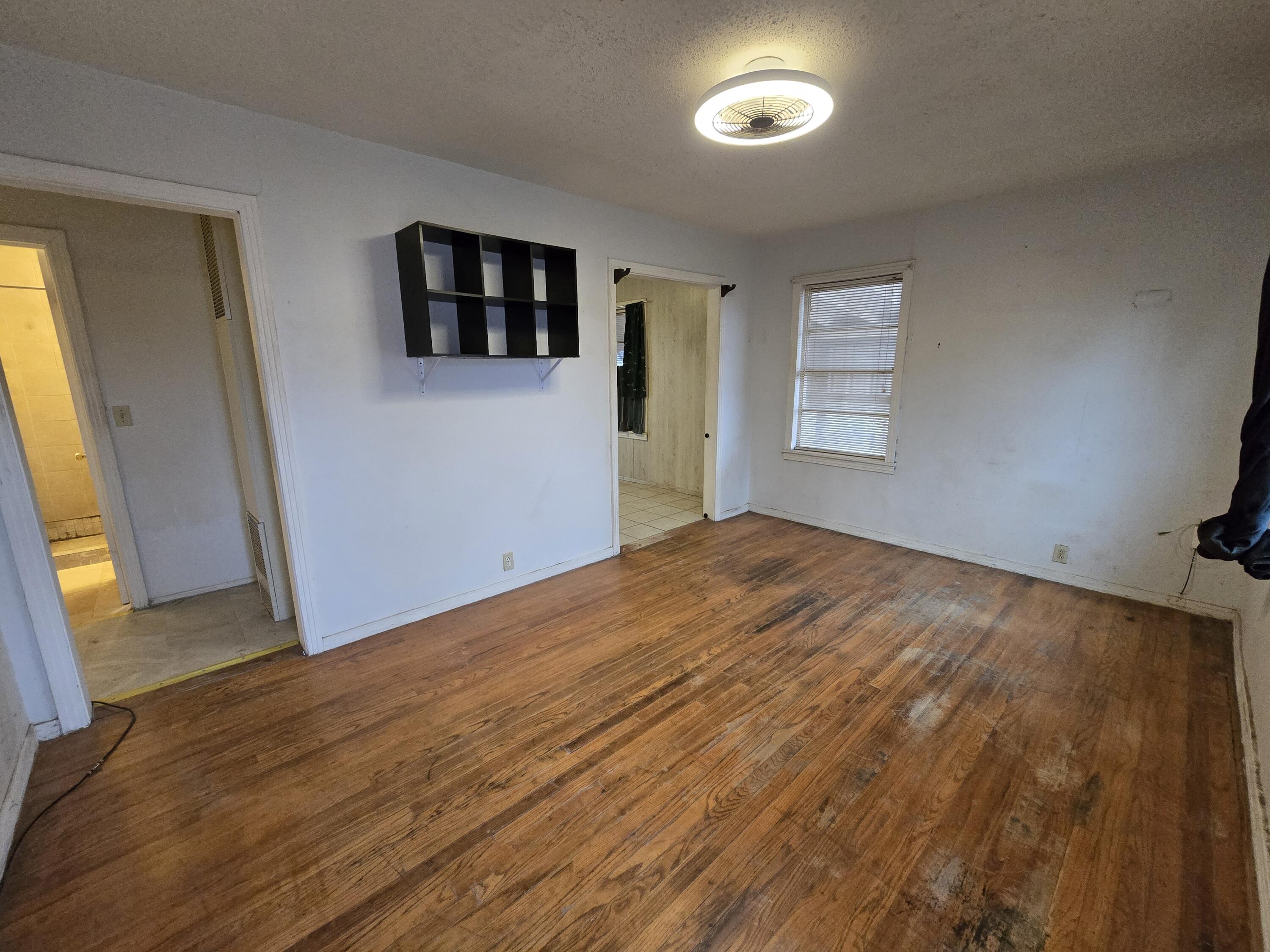 807 Northwest 8th Street Seminole, TX 79360 - Photo 3 of 15 a view of a room with wooden floor and a window