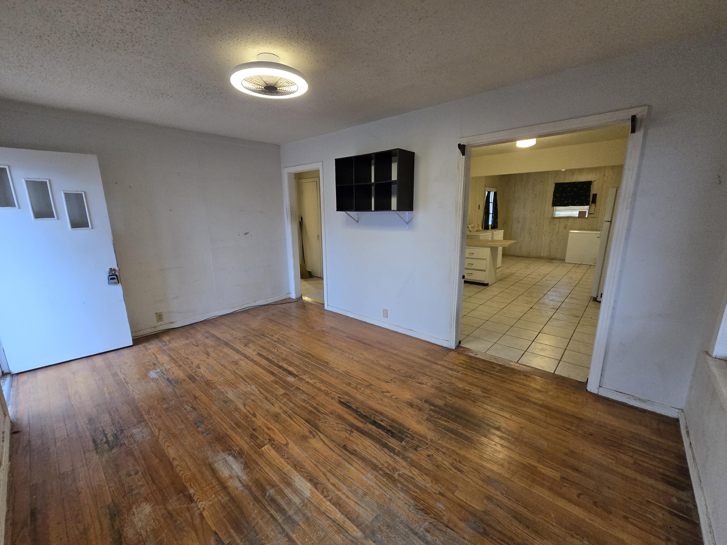 807 Northwest 8th Street Seminole, TX 79360 - Photo 4 of 15 a view of a livingroom with wooden floor and a flat screen tv