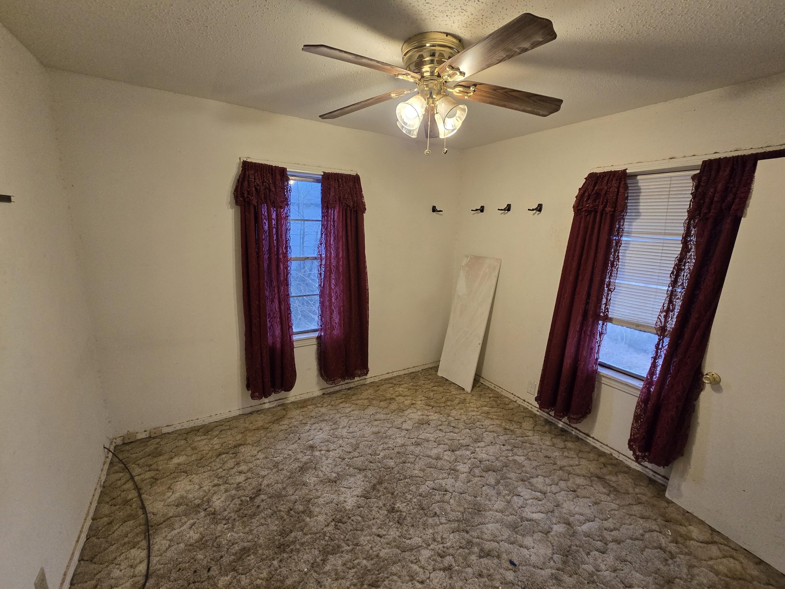 807 Northwest 8th Street Seminole, TX 79360 - Photo 10 of 15 a view of a room with a chandelier fan and wooden floor
