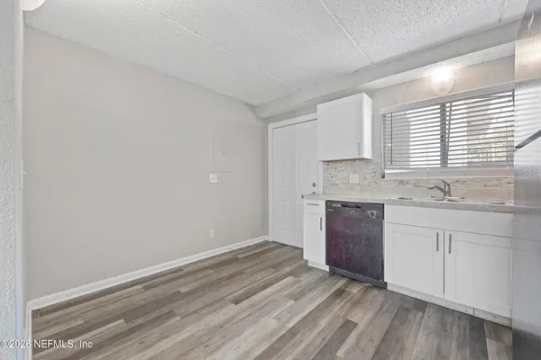 a kitchen with granite countertop white cabinets and white appliances