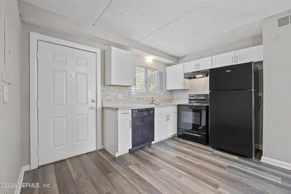 a kitchen with a refrigerator and a stove top oven