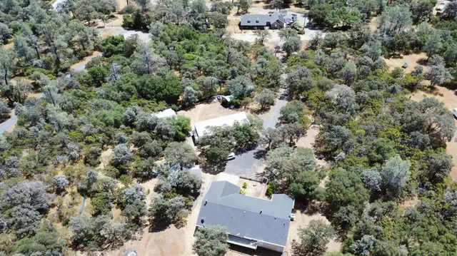 an aerial view of house with yard and mountain view in back