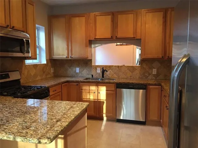 a kitchen with stainless steel appliances granite countertop a sink stove and refrigerator