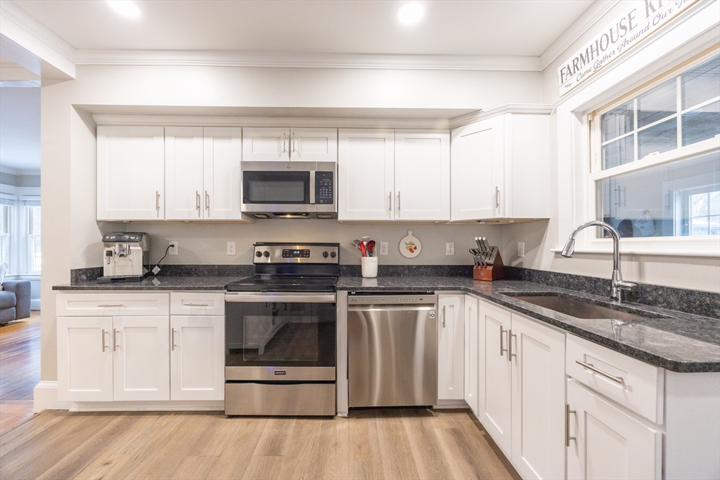 557 Dedham Street Wrentham, MA 02093 - Photo 16 of 42 a kitchen with stainless steel appliances granite countertop a stove a sink and white cabinets