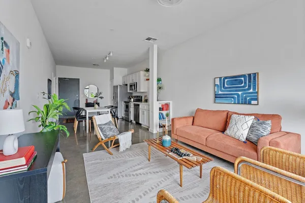 a living room with furniture kitchen view and a rug
