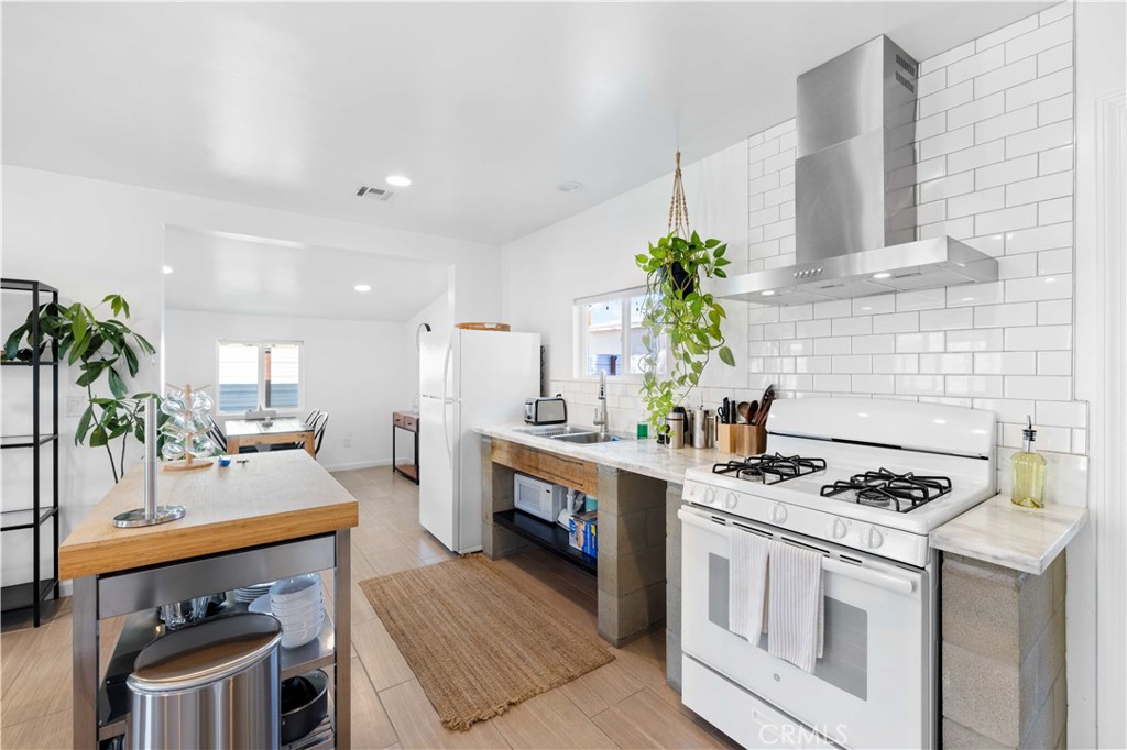 61879 Valley View Circle Joshua Tree, CA 92252 - Photo 11 of 63 a kitchen with stainless steel appliances a white table chairs and a stove