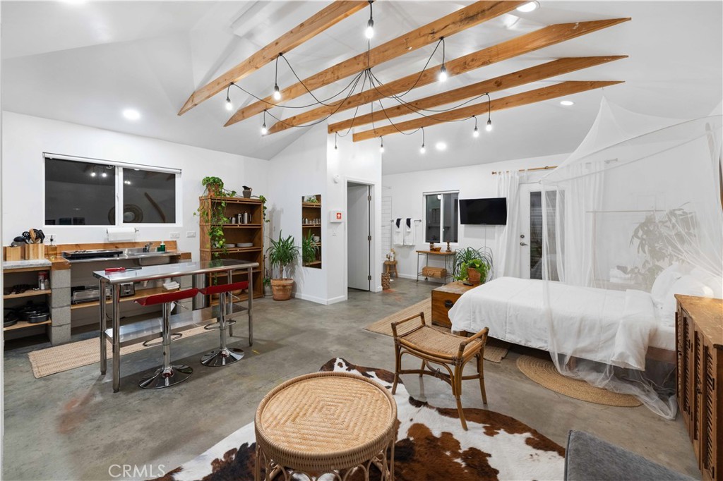 61879 Valley View Circle Joshua Tree, CA 92252 - Photo 48 of 63 a living room with furniture a flat screen tv and kitchen view