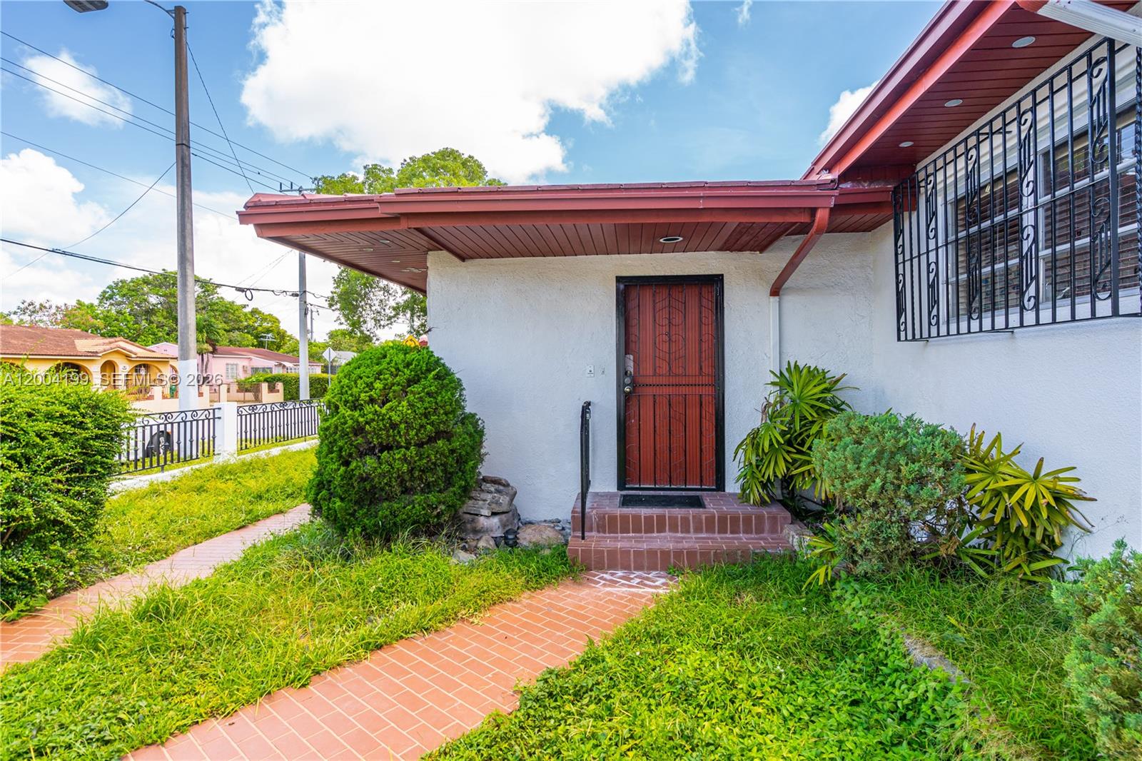 1841 Southwest 29th Avenue, Unit B Miami, FL 33145 - Photo 3 of 24 a view of a house with brick walls and a yard with plants