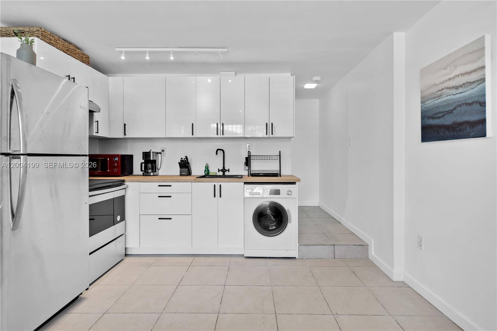 1841 Southwest 29th Avenue, Unit B Miami, FL 33145 - Photo 7 of 24 a kitchen with white cabinets and white appliances