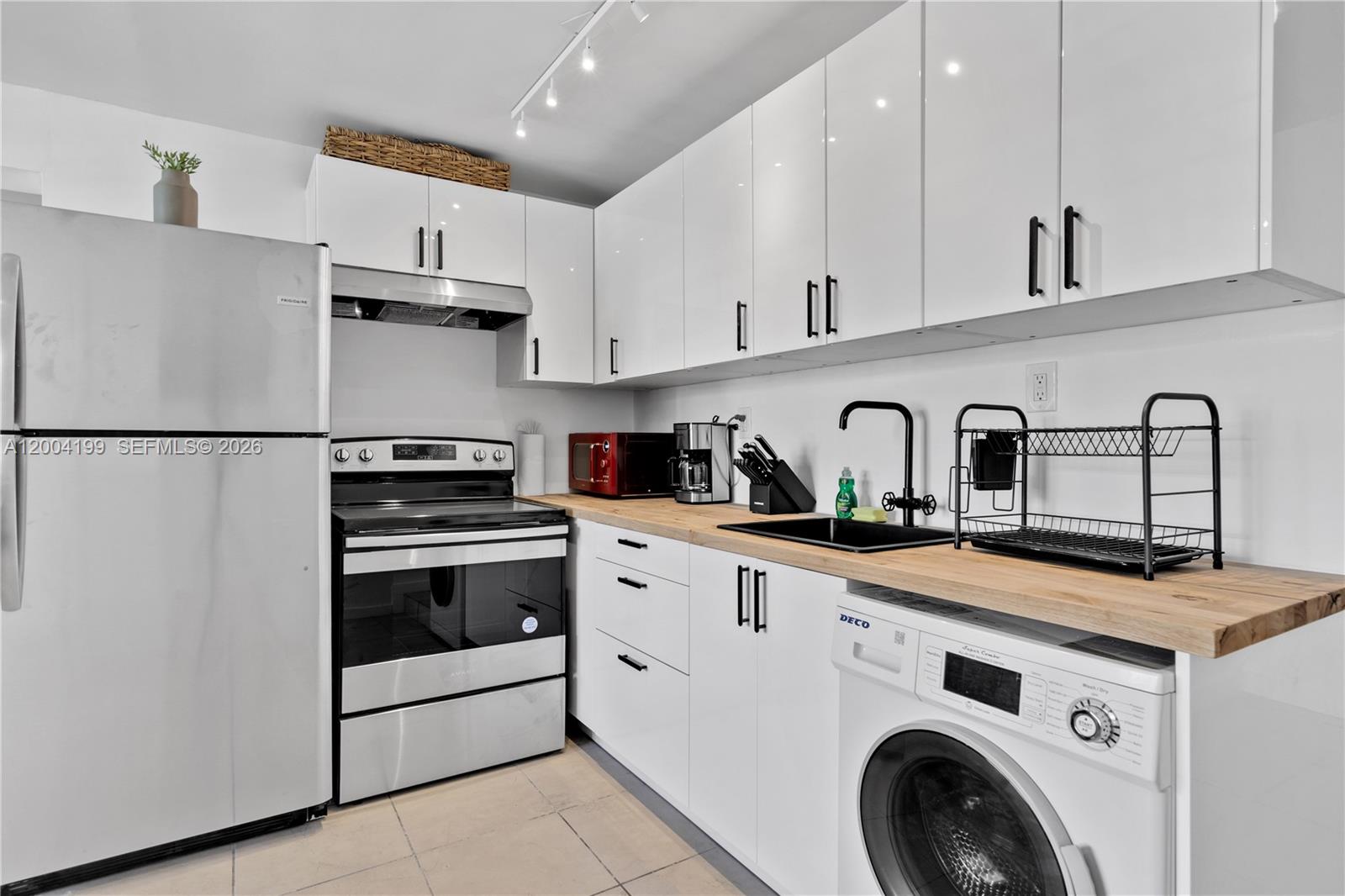 1841 Southwest 29th Avenue, Unit B Miami, FL 33145 - Photo 8 of 24 a kitchen with appliances a sink and cabinets