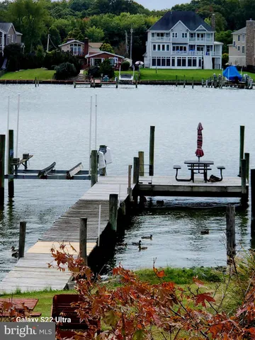 a view of a lake with lawn chairs and a table
