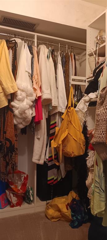 10145 Sunrise Lakes Boulevard, Unit 405 Sunrise, FL 33322 - Photo 32 of 48 a view of walk in closet with clothes and shoes