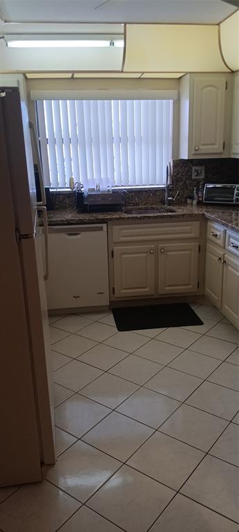 10145 Sunrise Lakes Boulevard, Unit 405 Sunrise, FL 33322 - Photo 8 of 48 a kitchen with a stove a sink and a refrigerator