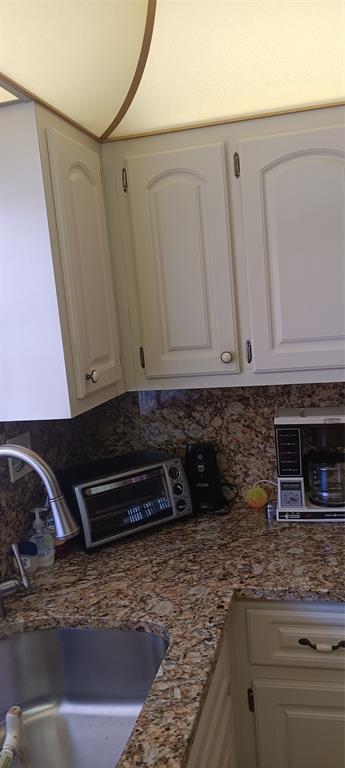 10145 Sunrise Lakes Boulevard, Unit 405 Sunrise, FL 33322 - Photo 10 of 48 a kitchen with granite countertop a sink and a stove