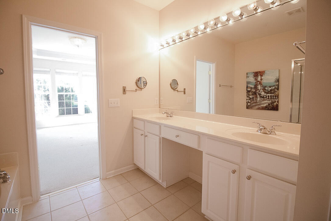 5335 Brandy Bay Road Raleigh, NC 27613 - Photo 14 of 29 a spacious bathroom with a double vanity sink a mirror and a shower