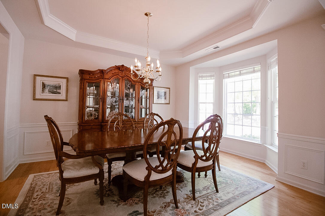 5335 Brandy Bay Road Raleigh, NC 27613 - Photo 5 of 29 a view of a dining room with furniture wooden floor and chandelier