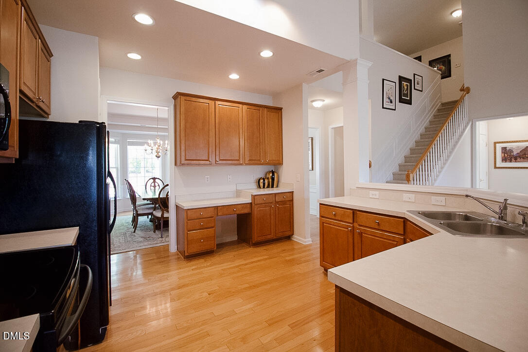 5335 Brandy Bay Road Raleigh, NC 27613 - Photo 6 of 29 a large kitchen with stainless steel appliances granite countertop a sink a stove a refrigerator a washer and dryer with wooden floor