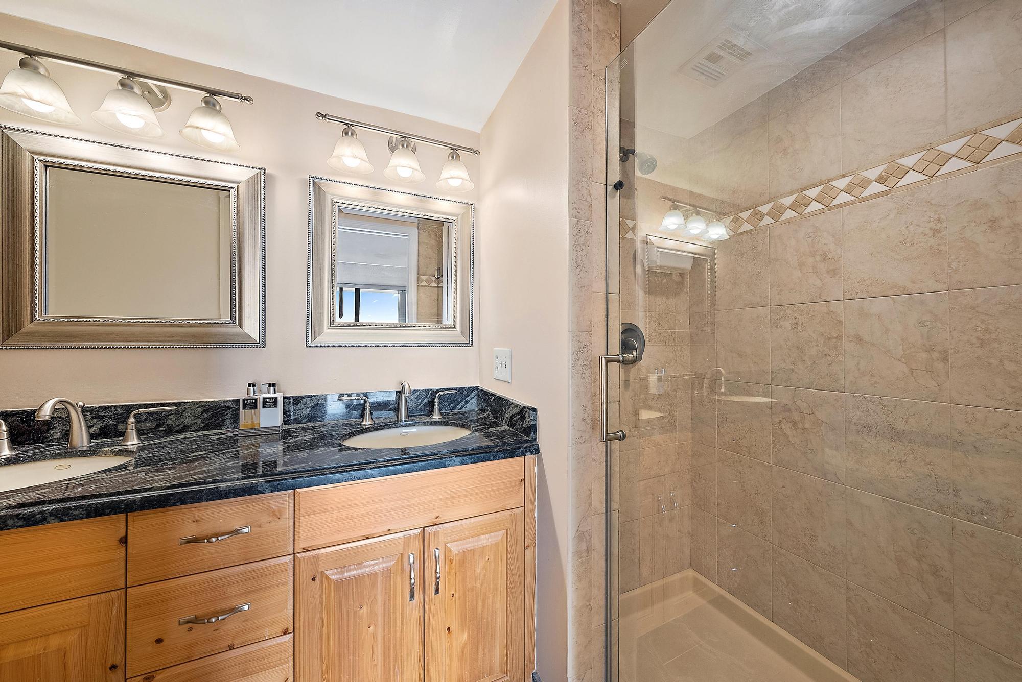 356 Golfview Road, Unit 805 North Palm Beach, FL 33408 - Photo 13 of 26 a bathroom with a granite countertop sink a mirror a vanity and shower