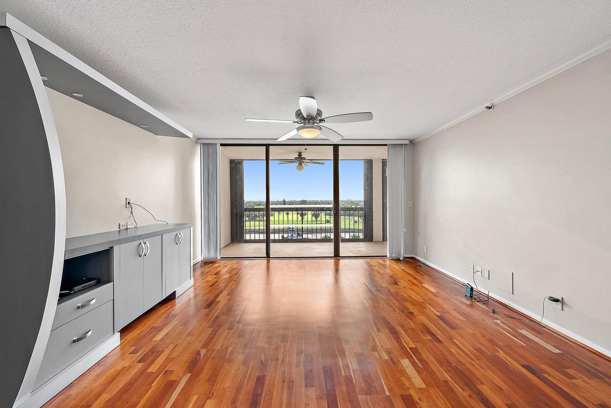 356 Golfview Road, Unit 805 North Palm Beach, FL 33408 - Photo 7 of 26 a view of an empty room with window wooden floor and a kitchen