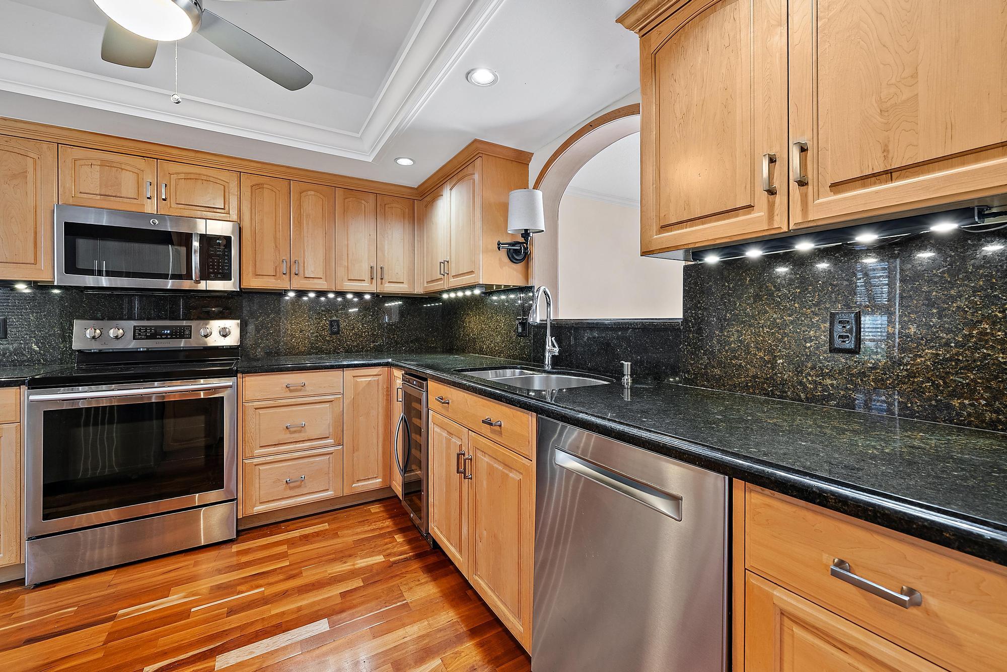 356 Golfview Road, Unit 805 North Palm Beach, FL 33408 - Photo 9 of 26 a kitchen with stainless steel appliances wooden cabinets a stove a sink and a microwave