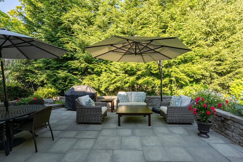 10 Elm Street Hingham, MA 02043 - Photo 19 of 19 a backyard of a house with table and chairs under an umbrella