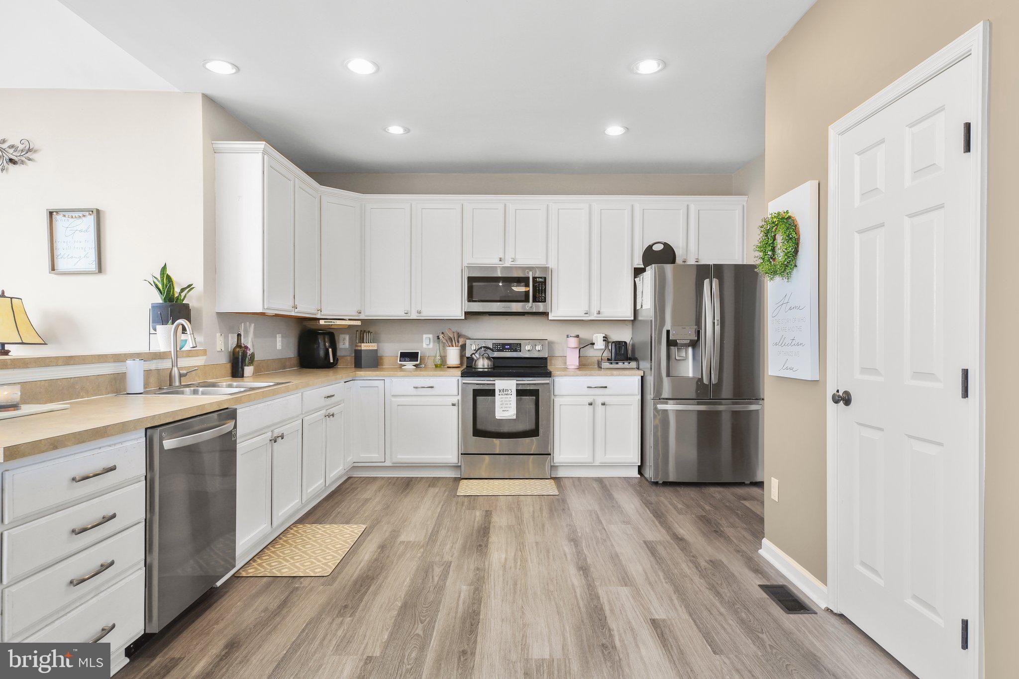 5233 Windbreak Drive Fredericksburg, VA 22407 - Photo 16 of 53 a kitchen with a refrigerator a stove top oven a sink and dishwasher with wooden floor