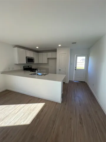 a kitchen with stainless steel appliances a refrigerator and a stove top oven